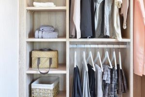 modern closet with row of cloths hanging in wooden wardrobe