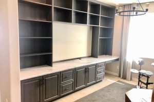 Entertainment - Dark wood wall unit with TV opening, desk, and shelves
