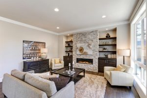 Entertainment - Warm wood cabinets and floating shelves by stone fireplace