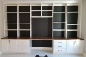 Home Office - White built in desk with wood countertop and black wall