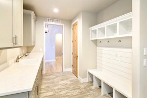 Laundry Room - Gray cabinets with sink and white shiplap bench seat with hooks