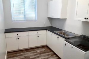 Laundry Room - White cabinets with black L-shape countertop