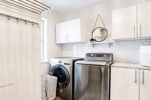 Laundry Room - White cabinets with satin nickel flat bar handles and subway tile backsplash