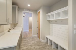 Mudroom and Seating - White bench with shoe cubbies and hooks create functional, stylish solution
