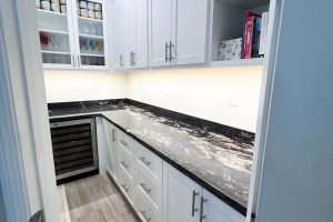 White Pantry with Glass Doors and Black Countertop