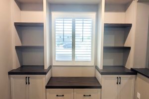 Window Seat with Built-In Cabinetry and Dark Tops